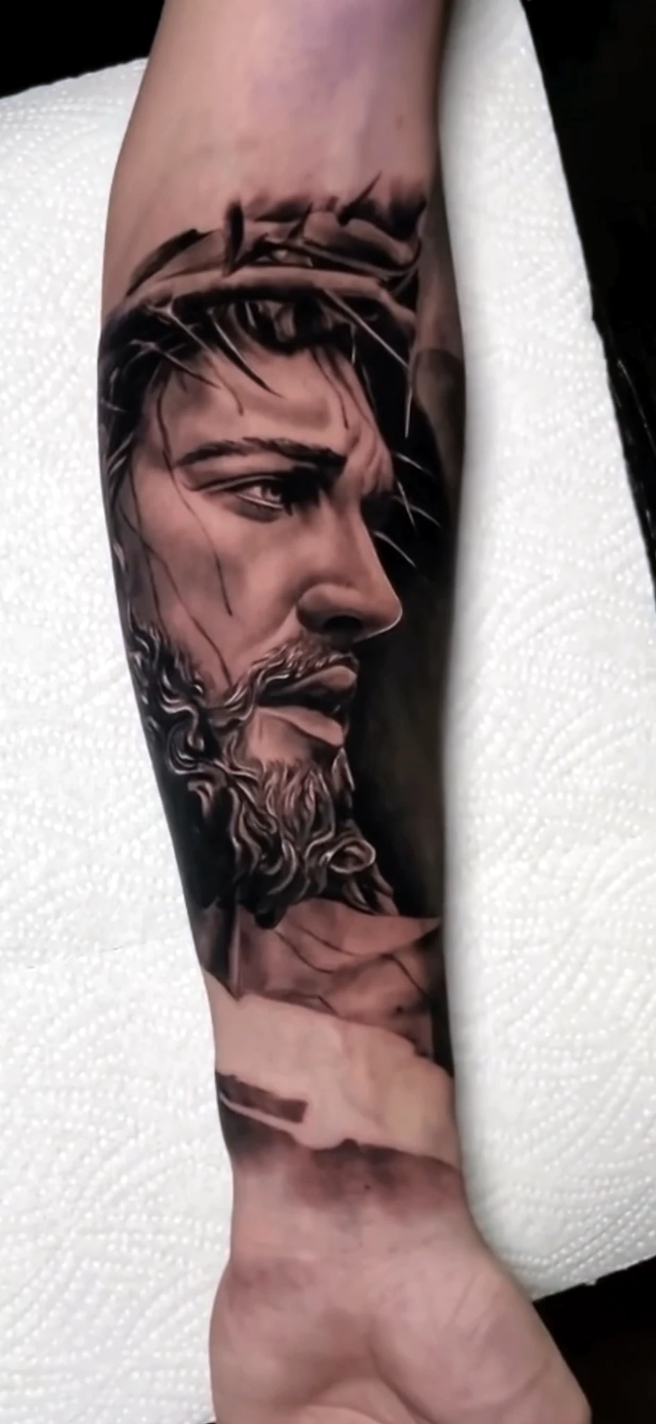 Black and grey realism Jesus portrait on the forearm by Rav Singh at Inkology