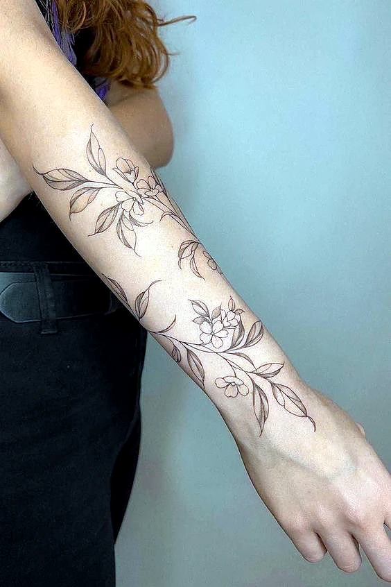 Fine line floral tattoo on the forearm by Rav Singh at Inkology