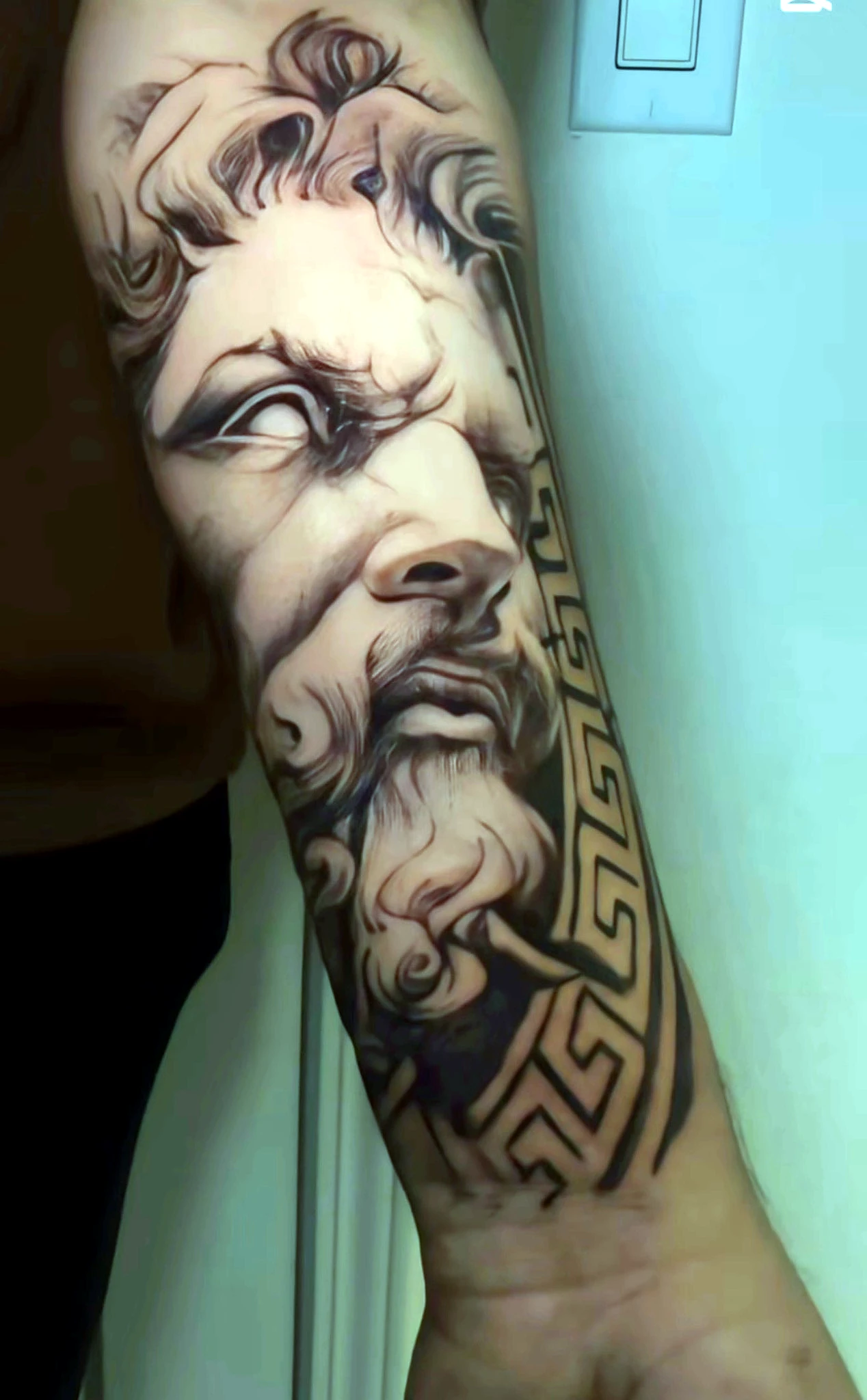 Black and grey realism Greek classical portrait on the forearm by Rav Singh at Inkology