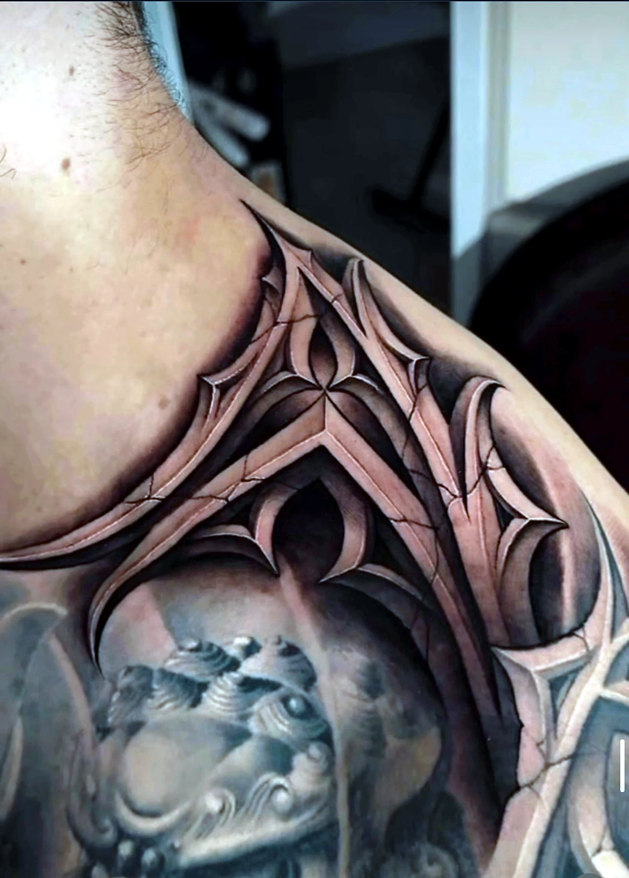 Ornamental tattoo across the neck and shoulder by Rav Singh at Inkology